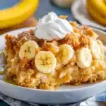 a close up of a plate of food with bananas and whipped cream on it next to a glass of milk