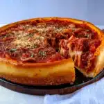 two different types of deep dish pizza on a wooden table with text overlay that reads deep dish pizza