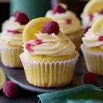 raspberry lemon heaven cupcakes with white frosting and fresh raspberries on top