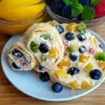 an assortment of fruit salad rolls on a plate with the words summer fruit salad roll ups
