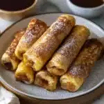cinnamon roll french toast on a plate with the words cinnamon roll in front of it