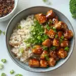 two bowls filled with rice, chicken and broccoli on top of each other