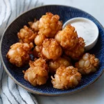 some fried food is on a plate with dipping sauces