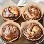 nutella banana muffins with chocolate frosting in the middle and one cut in half