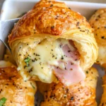 ham and cheese rolls in a white casserole dish