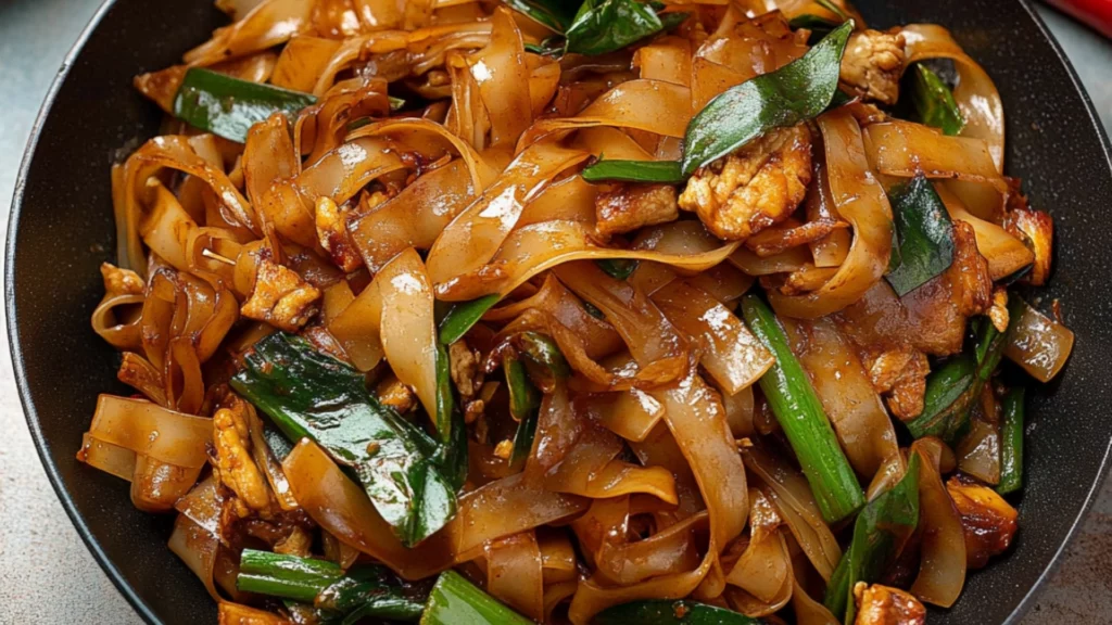 two pictures of stir fry noodles with chicken, peppers and green onions in a skillet