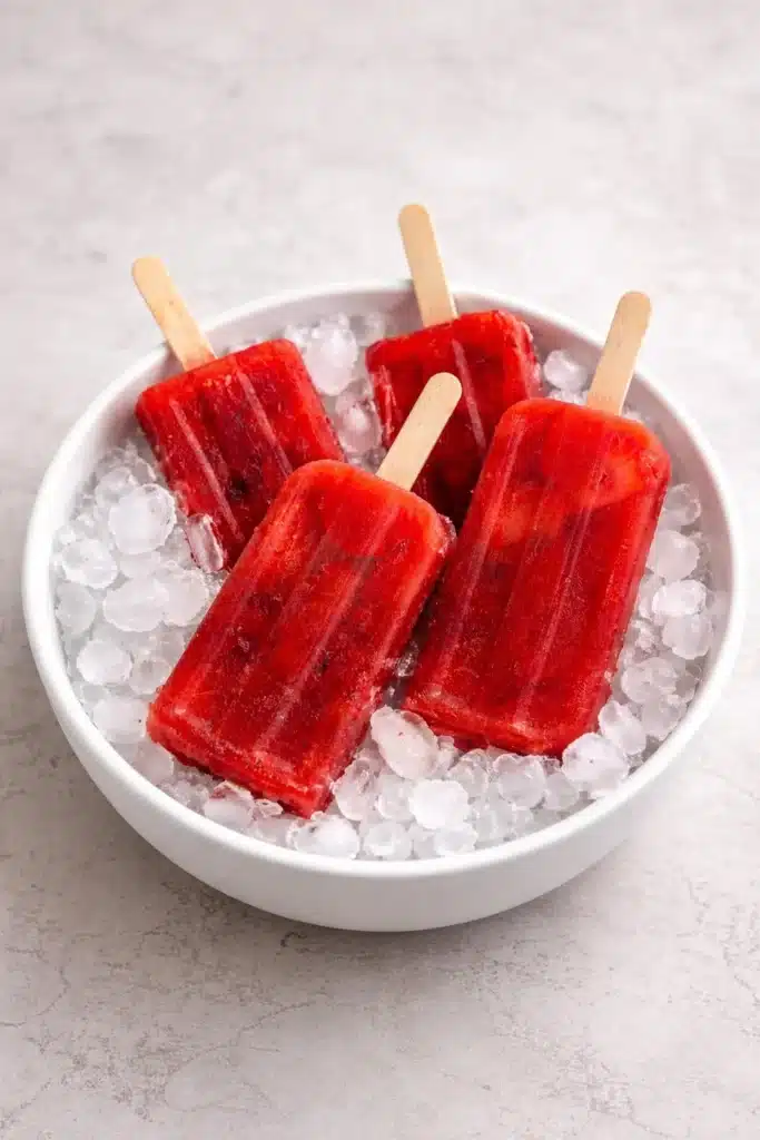 Homemade iced tea popsicles in colorful molds on a sunny day